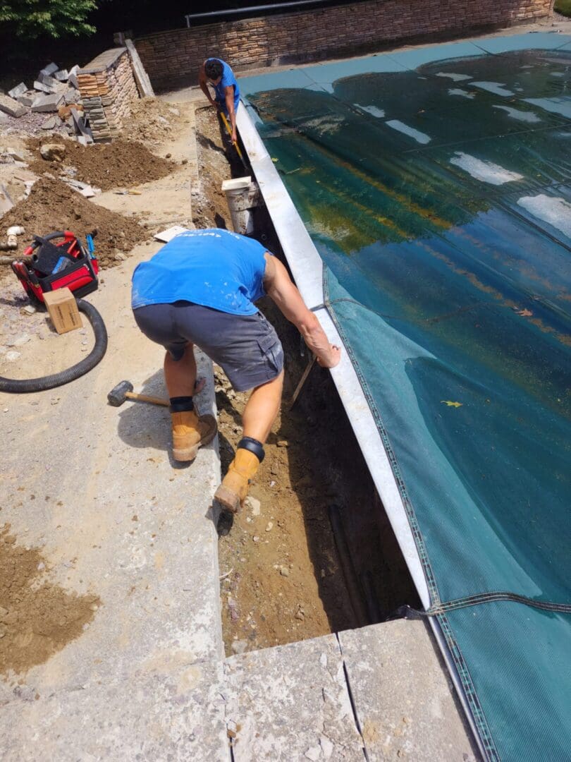 A man working on the side of a pool.