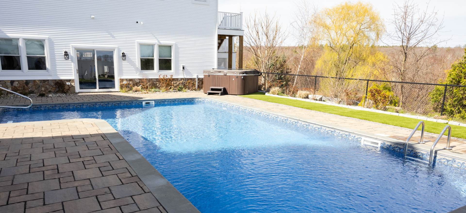 A pool with a hot tub in the back yard.